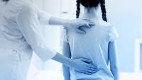 Healthcare provider examining a child's spine